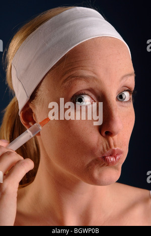Junge Frau mit einer Spritze in der hand Stockfoto