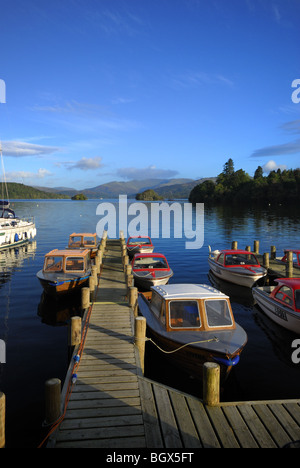 Boote an einer Anlegestelle in Bowness-on-Windermere am westlichen Ufer des Lake Windermere mit blauen Himmel und Sonne gefesselt Stockfoto