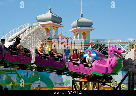 Reiten Sie die dumme Schlange im Luna Park, St Kilda, Melbourne, Australien. Dahinter ist die jahrhundertealte Scenic Railway Achterbahn Stockfoto