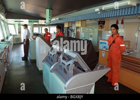 Kapitän und Crew-Mitglieder auf der Brücke eines Schiffes Hafen anlaufen. Stockfoto