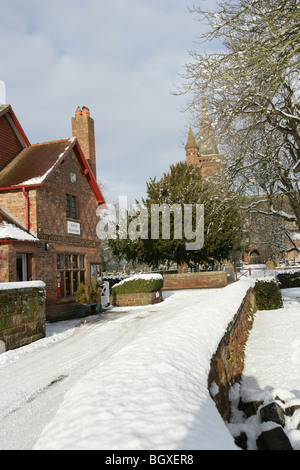 Dorf Aldford, England. Ländlichen Winter Blick auf das Dorf speichern mit St. Johannes der Täufer Kirche im Hintergrund. Stockfoto