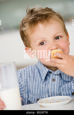 kleiner Junge Essen süße Knödel Stockfoto