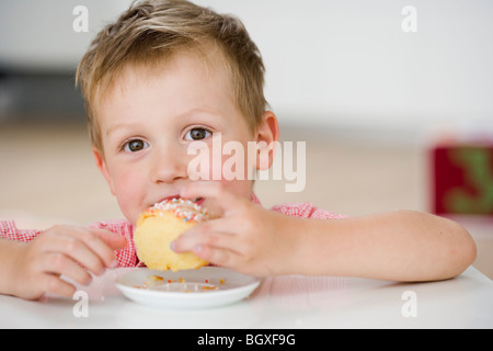 kleiner Junge Essen süße Knödel Stockfoto