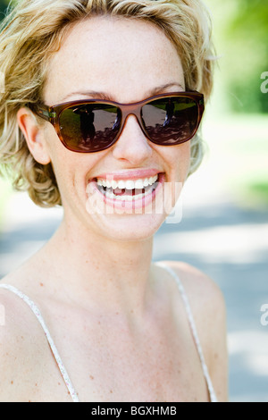 Frau mit Sonnenbrille Lächeln beim Betrachter Stockfoto