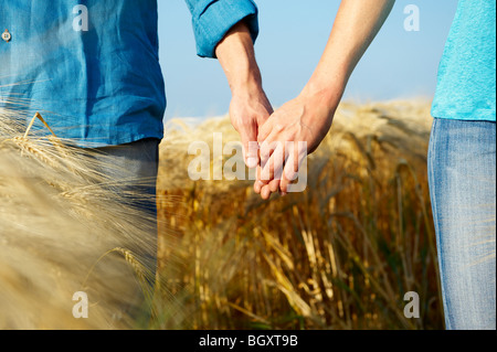 Paar halten die Hände in einem Weizenfeld Stockfoto