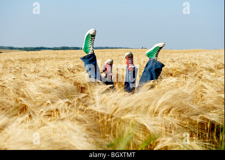 Füße heben sich aus einem Weizenfeld Stockfoto