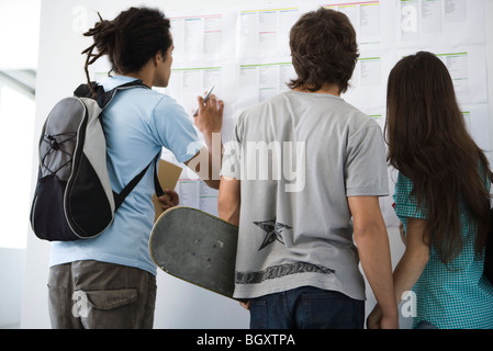 College-Studenten überprüfen Schwarzes Brett, Rückansicht Stockfoto