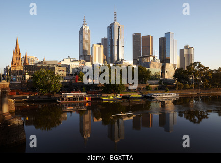 Ein Ruderer am frühen Morgen auf dem Yarra Fluss und die Stadt Skyline im Morgengrauen Melbourne, Victoria, Australia Stockfoto