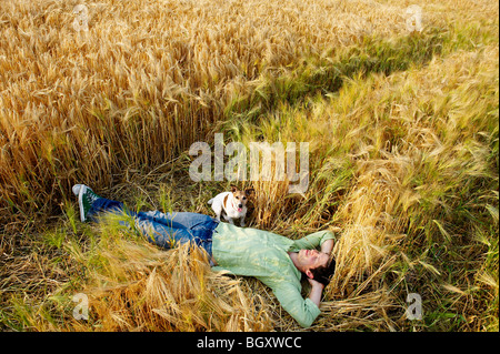 Mann mit Hund Festlegung im Weizenfeld Stockfoto