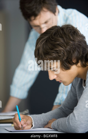 Schüler arbeiten unter Aufsicht des Lehrers Stockfoto