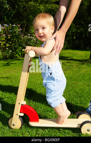 Baby Boy am Roller im Garten Stockfoto
