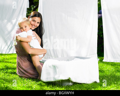 Mutter und Sohn kuscheln in der Wäscherei Stockfoto