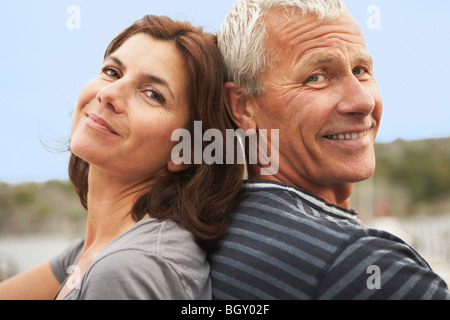 Applying paar, Rücken an Rücken, Lächeln Stockfoto