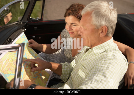 Älteres Paar mit Auto und Karte Stockfoto