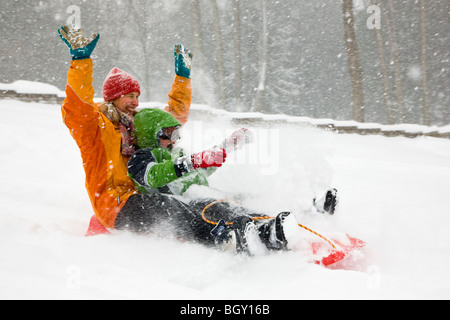 Mutter und Sohn Rodeln in einem Neuschnee. Stockfoto