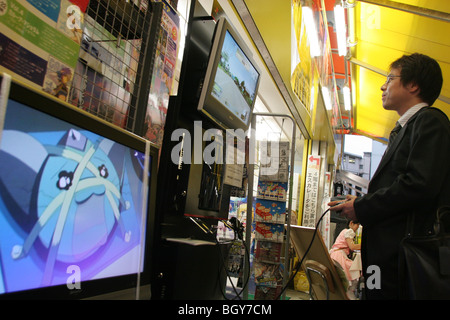 Kunden testen Sie die neue PlayStation3 Spielkonsole außerhalb eines Elektronikladen in Akihabara "Electric Town", Tokio Stockfoto