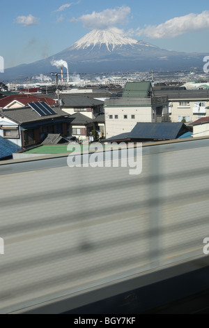 Mount Fuji, hinter einer Kulisse von landwirtschaftlichen und industriellen Landschaft, von einem Shinkansen-Hochgeschwindigkeitszug Fenster, Japan gesehen. Stockfoto