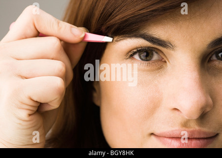 Junge Frau zupfen Augenbrauen Stockfoto