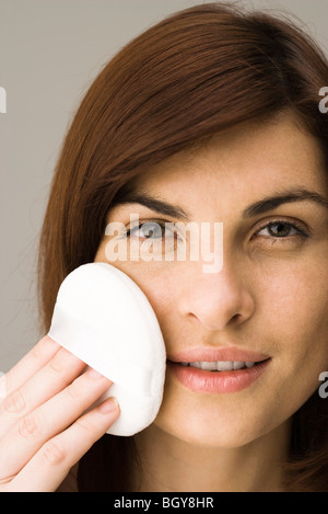 Junge Frau Gesichtspuder auftragen Stockfoto