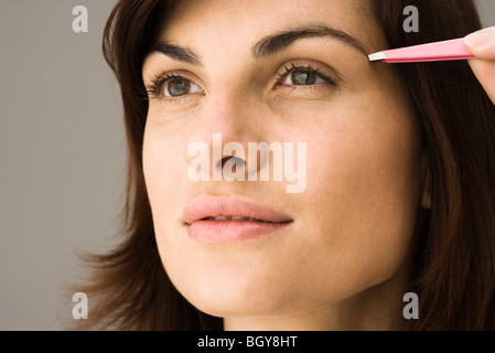 Junge Frau zupfen Augenbrauen Stockfoto