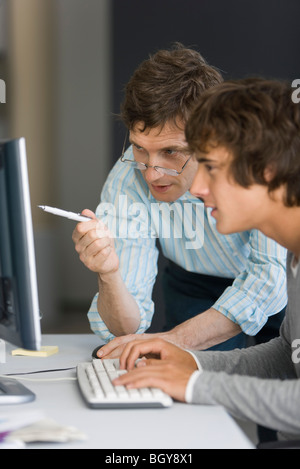 Lehrer, die Unterstützung der Schüler mit Computer-Zuordnung Stockfoto