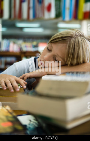 Junge Kopf ruht, auf Arme einschlafen in Bibliothek Stockfoto