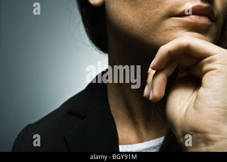 Frau mit der Hand unter Kinn, beschnitten Stockfoto