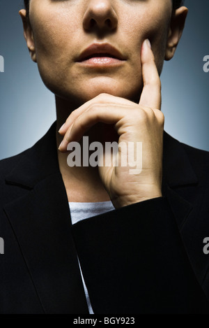 Geschäftsfrau mit Hand gehalten unter Kinn tief in Gedanken, Porträt Stockfoto