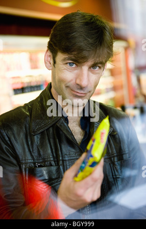 Mann an Supermarkt-Kasse kaufen snack Stockfoto