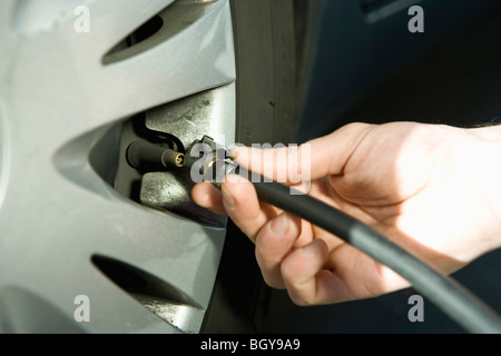 Fahrzeugreifen mit Luft Pumpe Schlauch aufpumpen Stockfoto