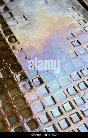 Motor-Öl in Wasser-Pfütze am Boden Stockfoto