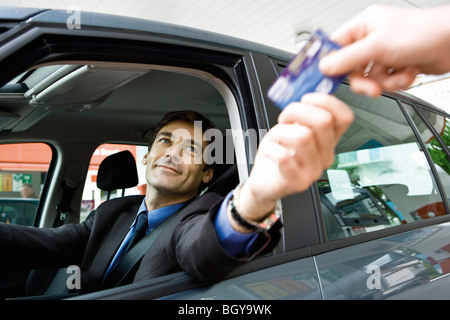 Kunden im Drive-in-Übergabe Kreditkarte zum Check-Out Fenster clerk Stockfoto