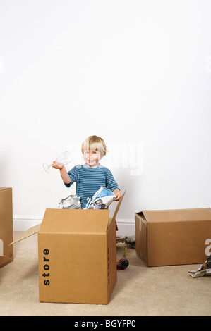 Junge Auspacken Gläser aus Karton Stockfoto