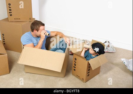 Vater und Sohn spielen mit Umzugskartons Stockfoto