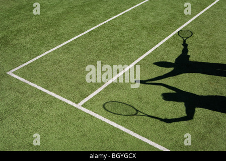 Schatten der Tennisspieler, die Erhöhung der gefalteten Hände zur Feier Stockfoto