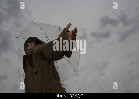 Frau mit Sonnenschirm, die Arme ausgestreckt und Kopf zurück, wegsehen, Lächeln Stockfoto