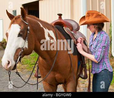 Frau Pferd Sattel aufsetzen Stockfoto