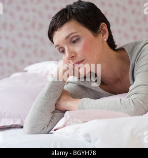 Frau auf Bett liegend Stockfoto