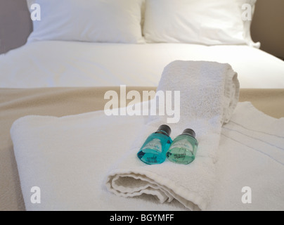 Handtücher und Shampoo auf einem Hotelbett angelegt Stockfoto