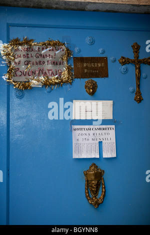 Des Malers Tür mit Nachrichten von Merry Christmas und Privatzimmer Vermietung in Venedig Stockfoto