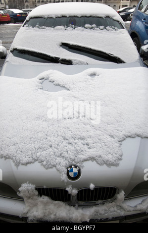 Eine schneebedeckte BMW Auto zeigt den Kühlergrill und Abzeichen Stockfoto