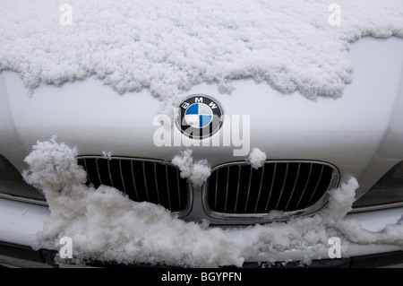 Eine schneebedeckte BMW Auto zeigt den Kühlergrill und Abzeichen Stockfoto
