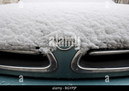 Eine schneebedeckte NISSAN Auto zeigt den Kühlergrill und Abzeichen Stockfoto