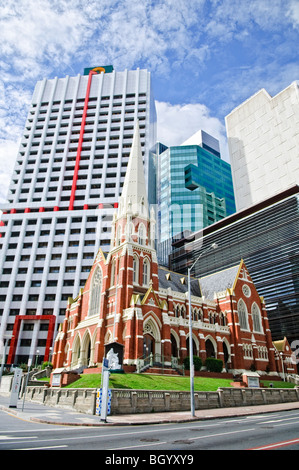 Albert Street Uniting Church Brisbane Australien | BRISBANE, Australien – die rote Backsteinfassade und der weiße Turm der Albert Street Uniting Church ragen unter den Glastürmen des zentralen Geschäftsviertels hervor. Die im späten 19. Jahrhundert für eine methodistische Gemeinde erbaute Gothic Revival Church erhielt ihren heutigen Namen 1977, als die Methodisten-, Presbyterian- und Kongregationskirchen Australiens zur Uniting Church zusammengeschlossen wurden. Stockfoto