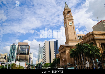 Brisbane City Hall Clock Tower Brisbane Australien / BRISBANE, Australien – der neoklassizistische Uhrenturm des Brisbane City Hall erhebt sich deutlich vor der modernen kommerziellen Skyline der Hauptstadt Queenslands. Das 1930 fertiggestellte Gebäude mit 302 Fuß (92 m) ist direkt architektonisch vom Markusplatz in Venedig inspiriert. Das denkmalgeschützte Gebäude bewahrt seine historische Funktion als aktiver Sitz des Stadtrates von Brisbane. Stockfoto