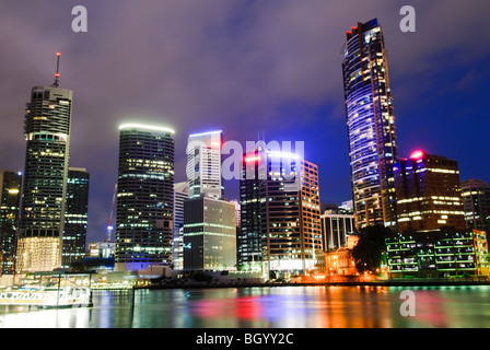 BRISBANE, Australien – die Skyline der Innenstadt von Brisbane bei Nacht, von der anderen Seite des Brisbane River im Captain Burke Park aus gesehen. Die beleuchteten Hochhäuser reflektieren das ruhige Wasser des Flusses und bieten einen atemberaubenden Blick auf die pulsierende Innenstadt der Stadt. Stockfoto