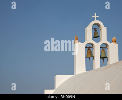 Weißer Kirchenglockenturm mit Kreuz und klarem blauem Himmel auf der Insel Santorin in Griechenland Stockfoto