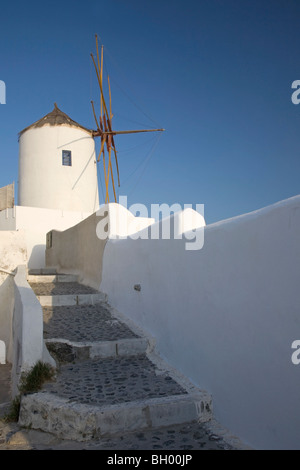 Kopfsteinpflaster-Treppe, die zur traditionellen Windmühle mit blauem Himmel auf der Insel Santorini in Griechenland führt Stockfoto