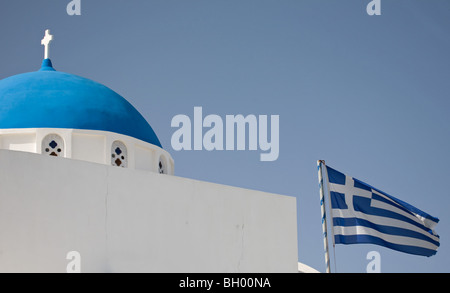Griechische Flagge und blaue Kuppelkirche in Imerovigli auf der Insel Santorini, Griechenland Stockfoto