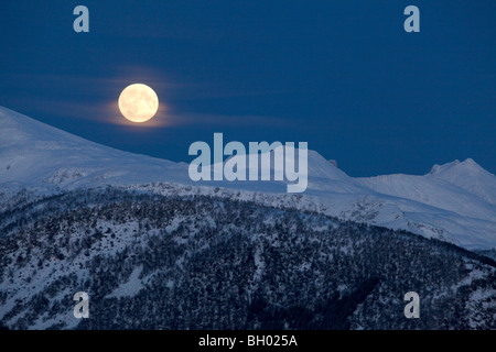 Vollmond über schneebedeckter Berg Stockfoto